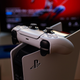A PlayStation 5 Console with the controller sitting on top of the machine standing in front of a TV showing the splash screen for Marve's Spiderman.